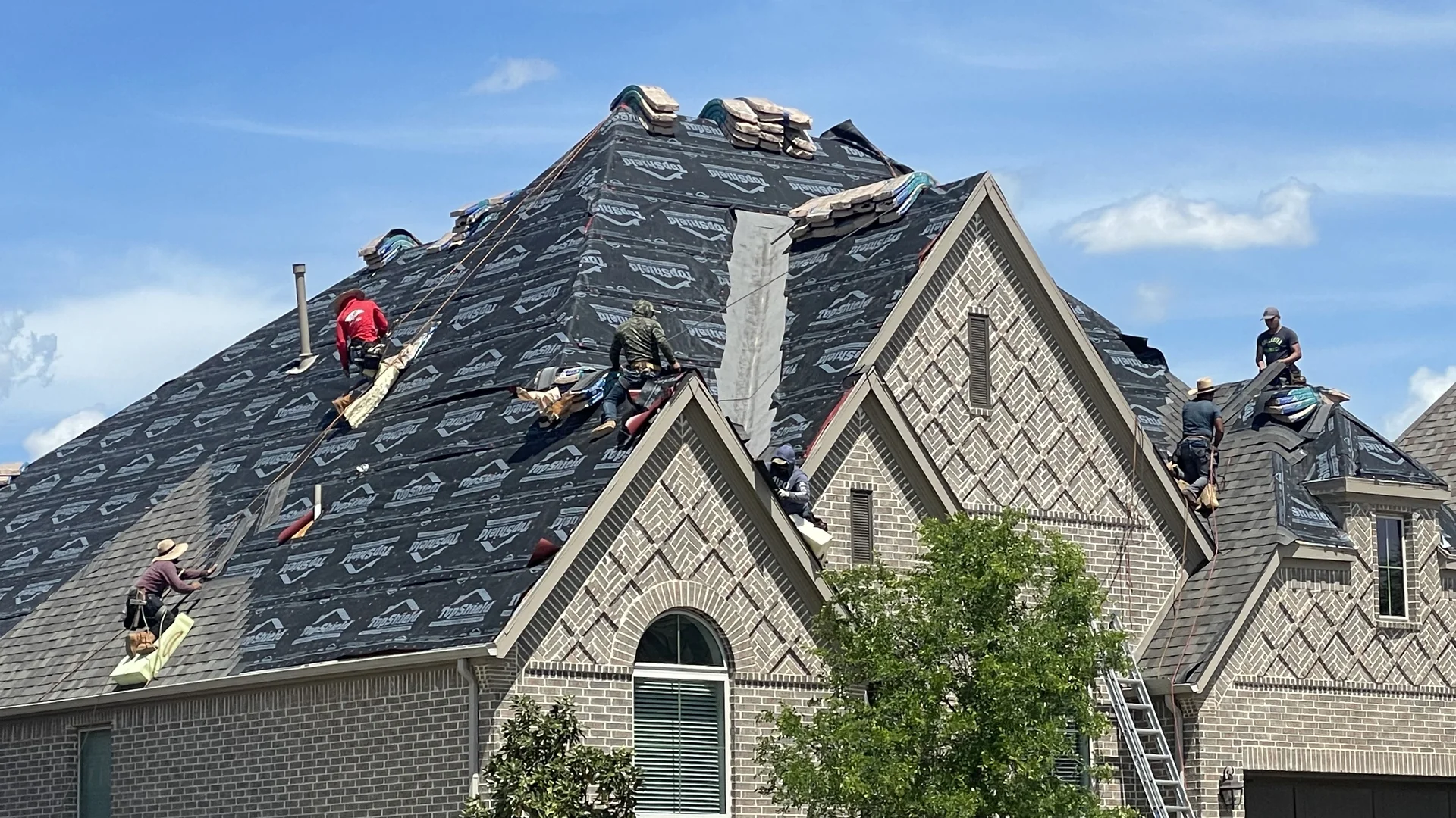 Celina roof underlayment installation in progress with roofing crews working across the roof planes
