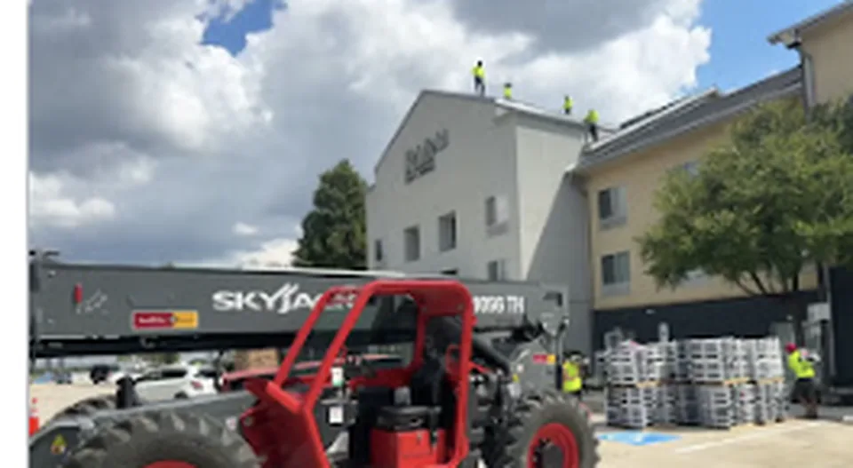 Frame Restoration crew on a multifamily commercial roof staged from a Skyjack lift in the DFW Metro